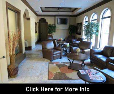 The waiting room of the office, dark brown sofas laid about.